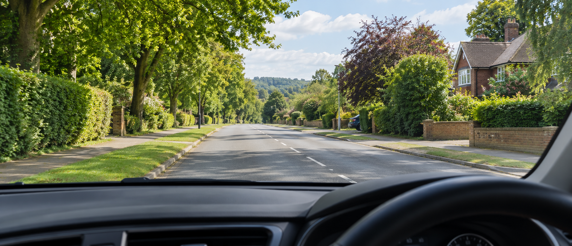 A learner driving on a leafy English road